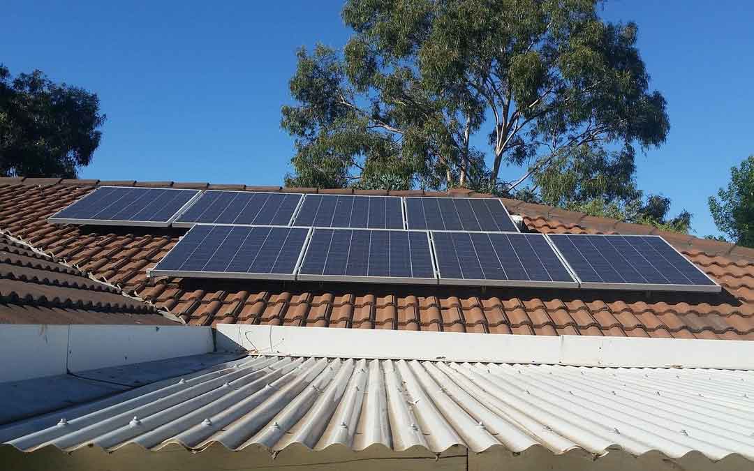 solar-panels solar panels on a tiled roof with a tree in the background